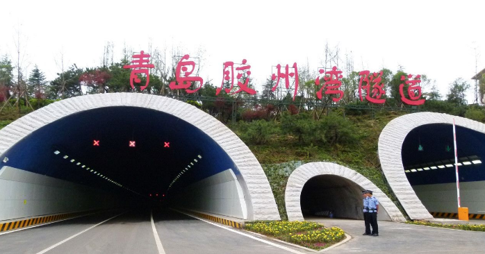 Portal of Jiaozhou Bay subsea tunnel with signage and landscaped slopes