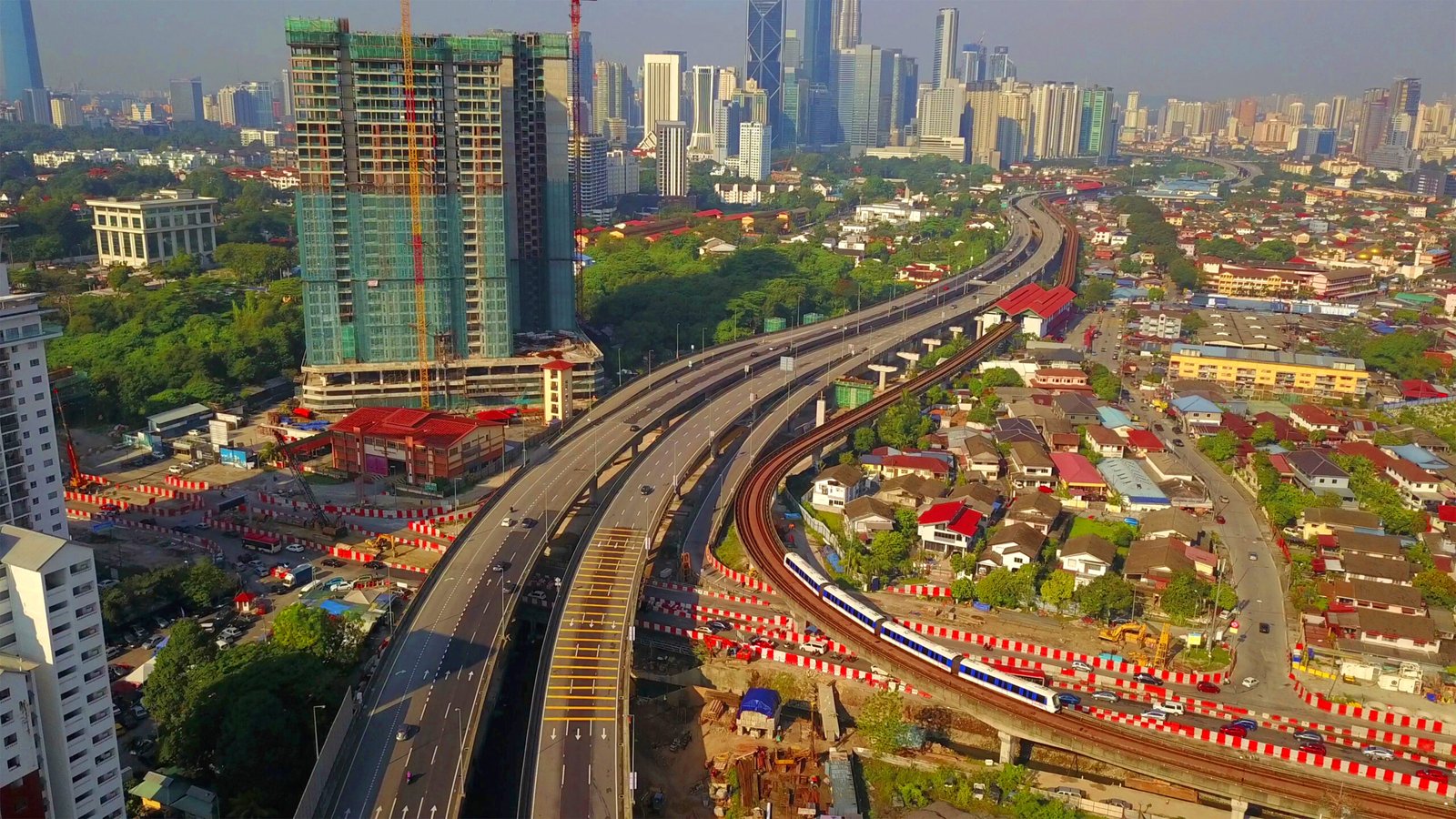 Elevated railway weaving through a dense Southeast Asian cityscape