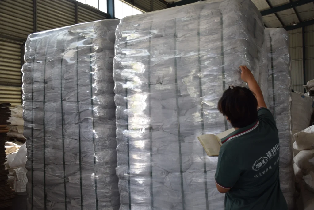 Ouvrier pesant des sacs de fibres de polypropylène avant de les ajouter dans un malaxeur à béton