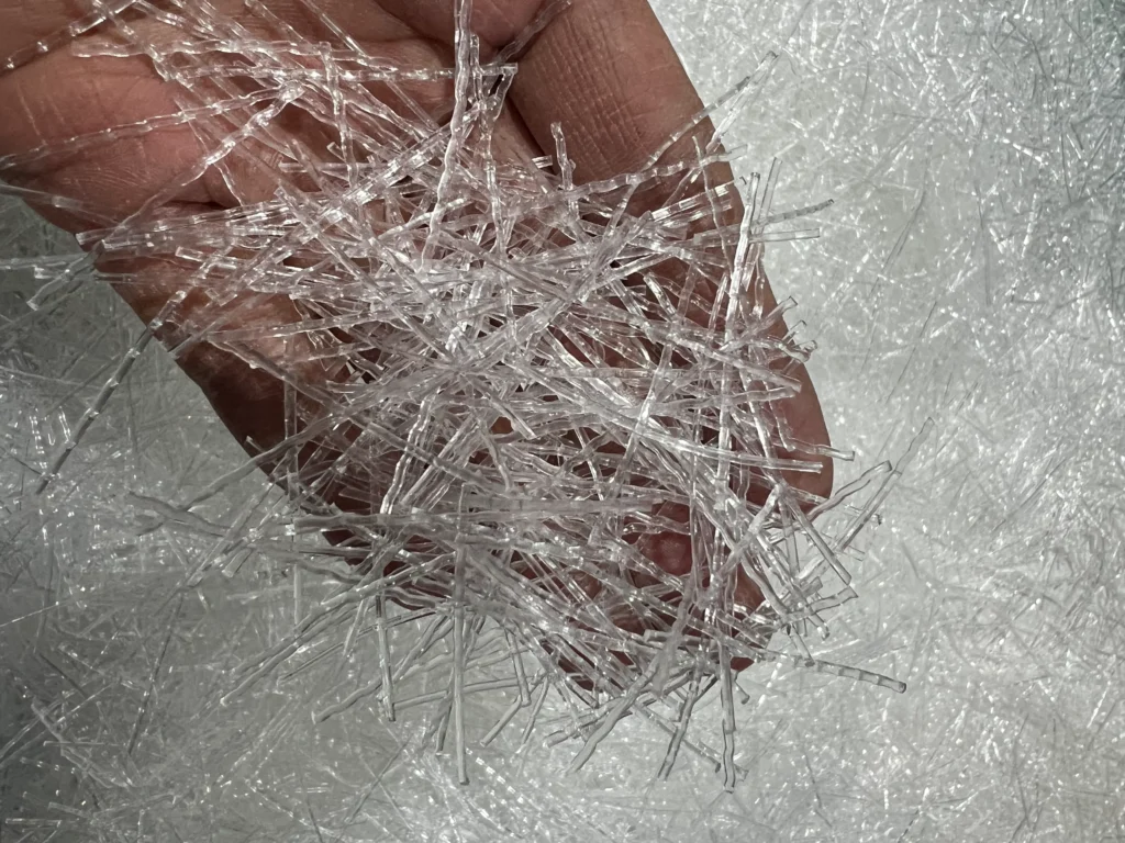 Vue rapprochée de faisceaux de fibres blanches en polypropylène utilisées comme renfort dans le béton et le mortier