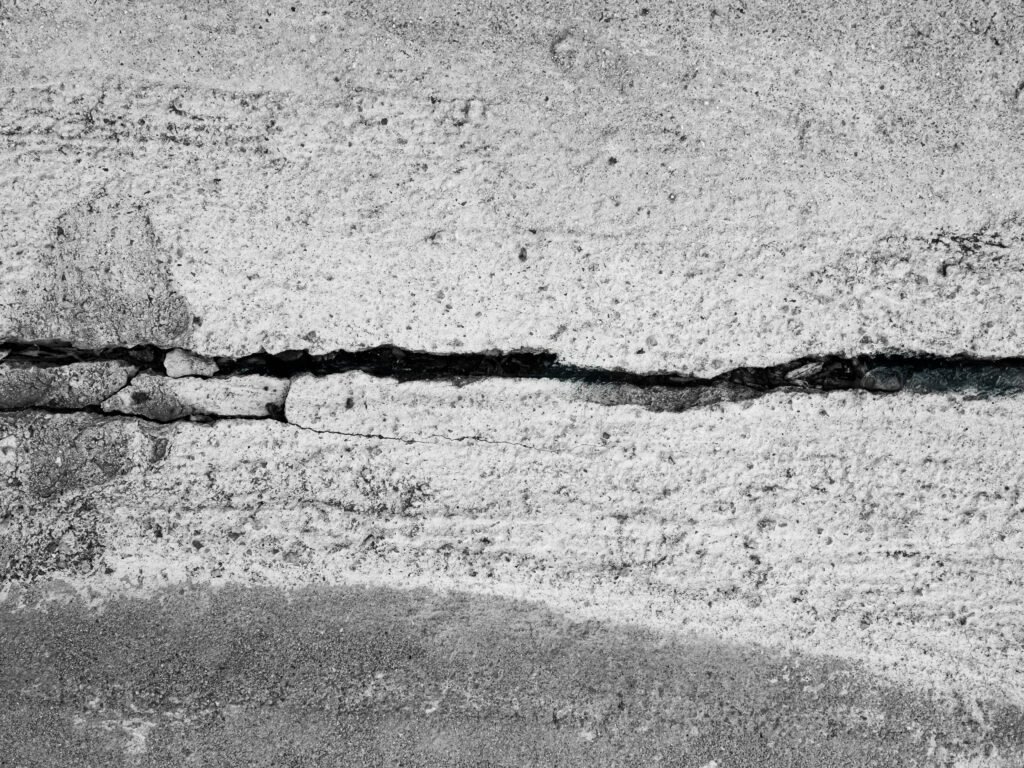 Sertleşmiş bir beton numunesindeki çatlakları köprüleyen çelik lifler, lif takviyesinin çatlakları nasıl sıkı tuttuğunu göstermektedir. Buna karşılık inşaat demiri belirli konumlara yerleştirilir ve bu tür mikro çatlakları erken yakalayamayabilir.