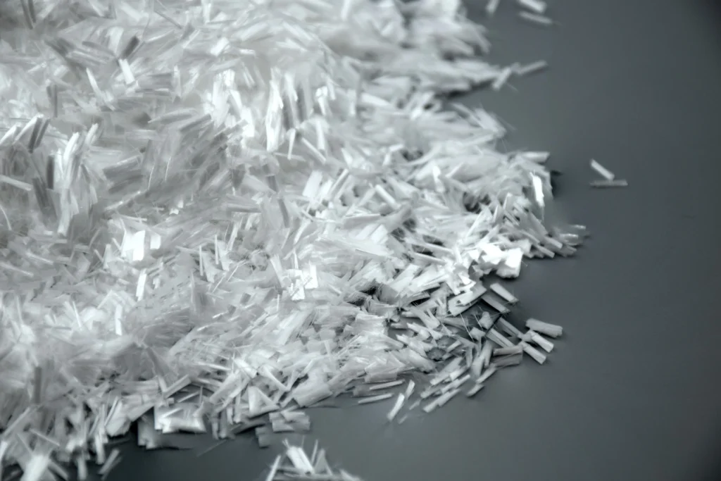 Primer plano de fibras de polipropileno utilizadas para controlar la fisuración y mejorar la tenacidad del hormigón.