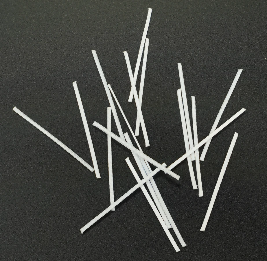 A magnified view shows the textured, indented surface of a polypropylene macrofiber.